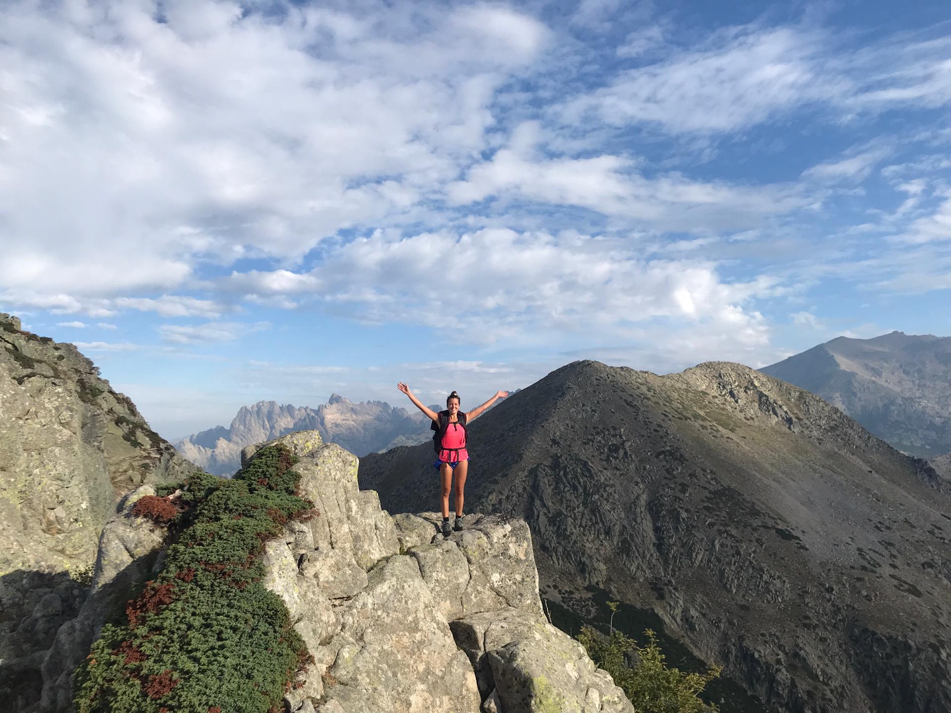 Caroline en montagne, bras ouverts au sommet